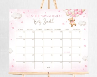 May include: A pink and white baby shower calendar with the text "Guess the Arrival Date of Baby Smith." The calendar features a teddy bear holding balloons, clouds, and stars. The calendar is displayed on a wooden easel.