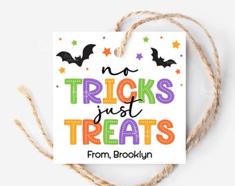 Puede incluir: Una etiqueta de regalo blanca de Halloween con el texto "no tricks just treats" en letras coloridas. La etiqueta presenta murciélagos, estrellas y el nombre "Brooklyn" en la parte inferior. Se adjunta un cordel de hilo natural.