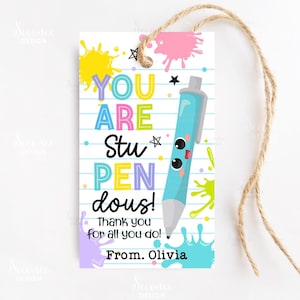 May include: A white gift tag with a lined paper design and a twine string. The tag features colorful text that reads "YOU ARE Stu PEN dous!" with a cartoon pen illustration and paint splatters. The text "Thank you for all you do! From. Olivia" is also included.