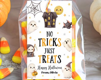以下が含まれることがあります： ハロウィーンをテーマにしたイラストが描かれた装飾タグが付いた、キャンディーコーンが詰まった透明なセロハンバッグ。「No Tricks Just Treats」と「Happy Halloween」という文字と名前が書かれています。お化け屋敷、お化け、コウモリが描かれています。