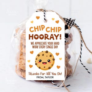 May include: White gift tag with brown text that reads "Chip Chip Hooray! We appreciate your hard work every single day. Thanks for all you do! From, Taylor". A cartoon chocolate chip cookie with a smiling face is in the center of the tag. There are small brown hearts scattered around the tag.