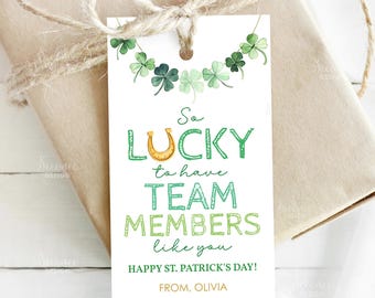 May include: A St. Patrick's Day gift tag with a watercolor shamrock garland. The tag reads "So Lucky to have Team Members like you" with a horseshoe graphic. The tag is tied to a wrapped gift with twine.
