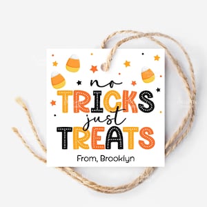 Op de afbeelding: Een vierkant wit Halloween-cadeaulabel met de tekst "no tricks just treats" in oranje en zwart. Het label bevat illustraties van snoepmaïs en sterren, met een touwtje van touw eraan. Het label luidt "From, Brooklyn".