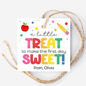 May include: A square gift tag with a twine string. The tag features colorful text that reads "a little TREAT to make the first day SWEET!" with an apple, stars, and a pencil graphic. The tag is personalized with the name "Olivia".