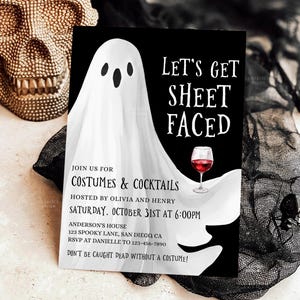 Może przedstawiać: Czarno-białe zaproszenie na imprezę Halloween z kreskówkowym duchem i kieliszkiem wina. Tekst brzmi "Let's Get Sheet Faced" i zaprasza gości na imprezę kostiumową 31 października.