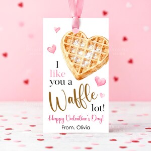 May include: A Valentine's Day gift tag with a heart-shaped waffle illustration. The tag reads "I like you a Waffle lot! Happy Valentine's Day! From. Olivia." Pink hearts and a pink ribbon complete the design.