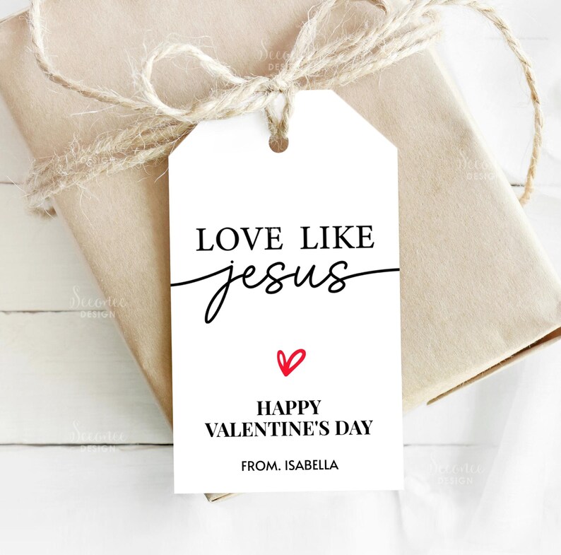 Pode incluir: Uma etiqueta de presente branca com o texto "LOVE LIKE Jesus" em escrita preta e um cora&ccedil;&atilde;o vermelho. Abaixo, l&ecirc;-se "HAPPY VALENTINE'S DAY" e "FROM. ISABELLA". A etiqueta est&aacute; amarrada a um presente embrulhado com barbante.
