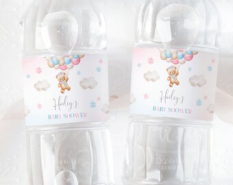 Könnte beinhalten: Zwei durchsichtige Plastikwasserflaschen mit Etiketten, die eine Aquarell-Illustration eines Teddybären mit Ballons zeigen. Die Etiketten sind rosa und blau mit weißen Wolken und Schneeflocken. Der Text auf den Etiketten lautet "Haileys Babyparty".