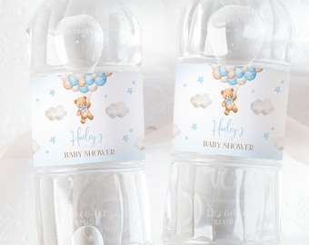 Könnte beinhalten: Zwei durchsichtige Plastikwasserflaschen mit blauen und weißen Etiketten. Die Etiketten zeigen einen Cartoon-Teddybär, der Ballons, Wolken und Sterne hält. Der Text auf den Etiketten lautet "Haileys Babyparty".