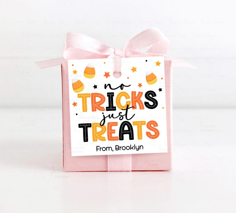 May include: A pink gift box tied with a light pink ribbon and bow. A white tag with the words "no tricks just treats" in orange, black, and yellow is attached. The tag also says "From, Brooklyn."