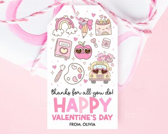 May include: A Valentine's Day gift tag with a pink and white design. The tag features illustrations of a rainbow, apple, school bus, and other school-themed items. The text reads "thanks for all you do! HAPPY VALENTINE'S DAY FROM. OLIVIA."