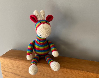Brightly coloured striped crochet giraffe
