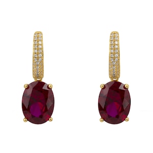 Peut inclure: Une paire de boucles d'oreilles en or avec une pierre ovale rouge et un halo de petites pierres claires.
