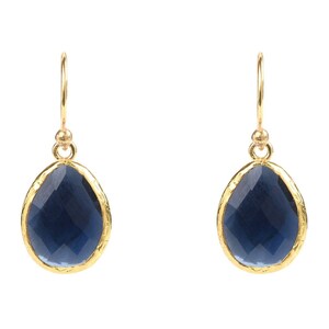 Peut inclure: Une paire de boucles d'oreilles pendantes en or avec une pierre précieuse bleu foncé en forme de larme.