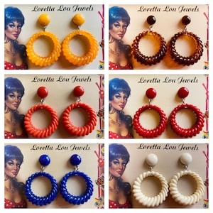 May include: Six pairs of vintage earrings with a textured hoop design. The earrings come in yellow, brown, red, blue, and white. Each pair has a round hoop and a stud. The brand name "Loretta Lou Jewels" is visible.
