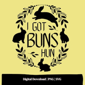 Puede incluir: Diseño en silueta negra y blanca de conejos con una corona de hojas a su alrededor. El texto "I got buns hun" está escrito en una fuente decorativa.