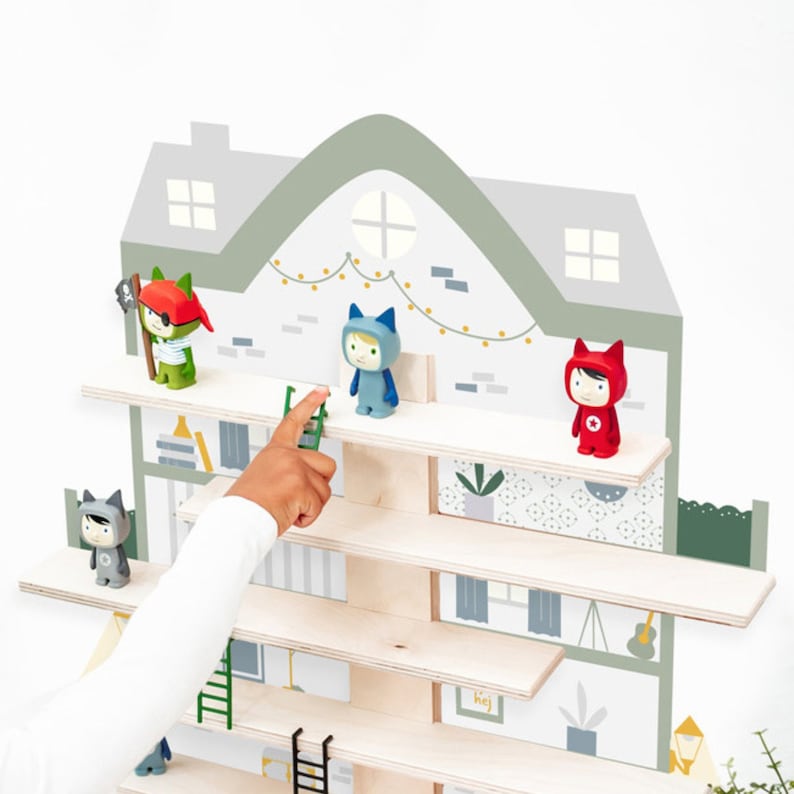 May include: A wooden shelf unit shaped like a house with a green roof and gray walls. The shelves are decorated with a whimsical wallpaper pattern and feature small figurines of animals wearing hats. The shelves are mounted on a white wall.