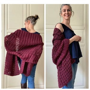 May include: A burgundy crochet shawl with a lacy pattern. The shawl is draped over the shoulders of a person wearing a blue tank top and jeans.