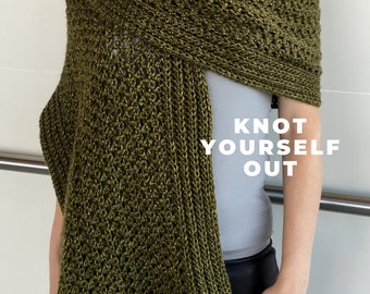 May include: A green crochet shawl with a knotted fringe. The shawl is draped over a person's shoulders and the text "Knot Yourself Out" is visible in the image.