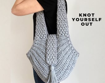 May include: A gray crocheted tote bag with a tassel. The bag has a unique textured design and is worn over the shoulder.