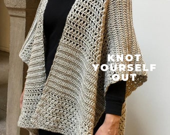 May include: A crocheted shawl in a light brown and grey colour with a lacy pattern. The shawl is draped over a person's shoulders and has a text overlay that reads "Knot Yourself Out".