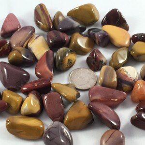 May include: A collection of tumbled stones in shades of red, brown, yellow, and white. The stones are smooth and polished, with a variety of patterns and textures.