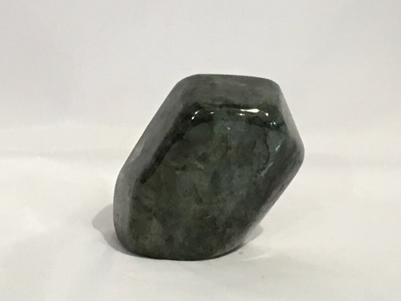 May include: A dark green, irregularly shaped, polished stone with a smooth, glossy surface.