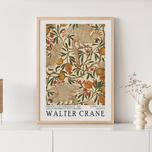 以下が含まれることがあります： クリーム色の背景に、白いコカトゥー、ザクロの実、緑の葉が繰り返し描かれたヴィンテージポスター。ポスターは木製のフレームで囲まれており、下部に「COCKATOOS AND POMEGRANATE - 1891 COLOUR WOODBLOCK PRINT ON PAPER WALTER CRANE JEFFREY & CO LONDON」というテキストが書かれている。