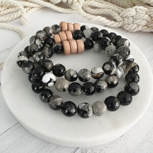 May include: Three layered bracelets with black and gray agate beads and wooden spacers.