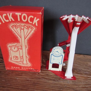 May include: Vintage "Tick Tock" sand shovel toy with original box. The red box features the toy's name and illustration. The toy itself is red and white with a clock face. A classic toy for children.