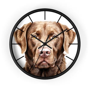 Puede incluir: Un reloj de pared redondo con marco negro y agujas negras presenta un perro Labrador Retriever marrón con una expresión seria.
