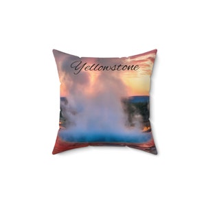 May include: A throw pillow with a colorful image of a geyser erupting in Yellowstone National Park. The text "Yellowstone" is printed in black cursive on the pillow.