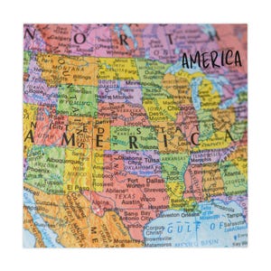 Può includere: Una mappa colorata degli Stati Uniti, con la parola "AMERICA" in grassetto. La mappa evidenzia stati, città e caratteristiche geografiche, offrendo una vista dettagliata del paesaggio del paese. La mappa è di forma quadrata.