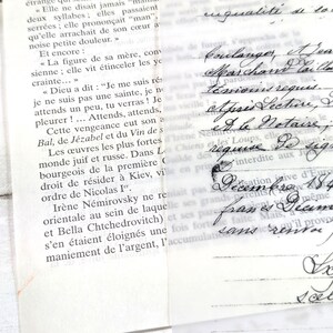 May include: Close-up of aged paper with French text and handwritten script. The paper is slightly yellowed, with visible text from a book and cursive writing. The image evokes a vintage or antique aesthetic.