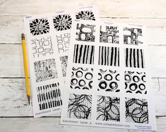 May include: Two sheets of white Avery labels featuring black ink patterns including floral shapes, geometric squares, numbers, stripes, circles, and scribbles. A yellow pencil is placed next to the sheets, which are labeled Assortment Large and Assortment Large A.