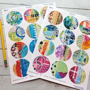 May include: A white ceramic mug with a black handle and the text "But First, Coffee" in a bold, black font. The mug is set against a blurred background, suggesting a cozy setting.