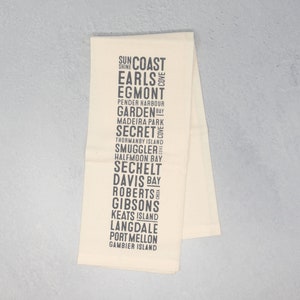 Könnte beinhalten: Ein weißes Küchentuch mit schwarzem Text, der verschiedene Orte auflistet, darunter Sun Coast, Earls, Egmont, Garden Bay, Madeira Park, Secret Cove, Smuggler, Halfmoon Bay, Sechelt, Davis Bay, Roberts Creek, Gibsons, Keats Island, Langdale, Port Mellon und Gambier Island.
