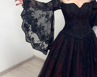 May include: A black formal gown with a sweetheart neckline and long, flared sleeves. The bodice is fitted and adorned with lace, and the skirt is a full, layered design with a dark red underlay. The sleeves have a floral lace pattern.