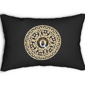 May include: Black pillow with a gold decorative circle featuring a white letter Q and a gold crown.
