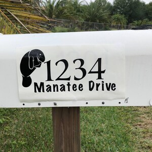 May include: White mailbox with a black manatee silhouette and the address 1234 Manatee Drive.