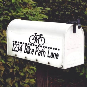 May include: White mailbox with a black bicycle graphic and the text "1234 Bike Path Lane" on the front.