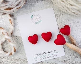 Puede incluir: Tres marcadores de punto de silicona en forma de corazón rojo en una tarjeta blanca con el texto "THE DESERT STREAM" y "CRAFT • DESIGN • CREATIVITY" y la dirección del sitio web "WWW.THEDESERTSTREAM.COM".