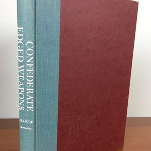 May include: A book titled "Confederate Edged Weapons" by Albaugh, with a blue spine and a maroon cover.