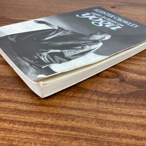 May include: A book titled "Aleister Crowley: Eight Lectures on Yoga" is shown on a wooden surface. The book cover features a black and white image of a robed figure. The title is in a stylized font with a teal accent.