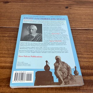 May include: A book titled "Eight Lectures on Yoga" with a blue cover and a black and white image of a man. The book is published by New Falcon Publications and includes text about yoga, philosophy, and the author.