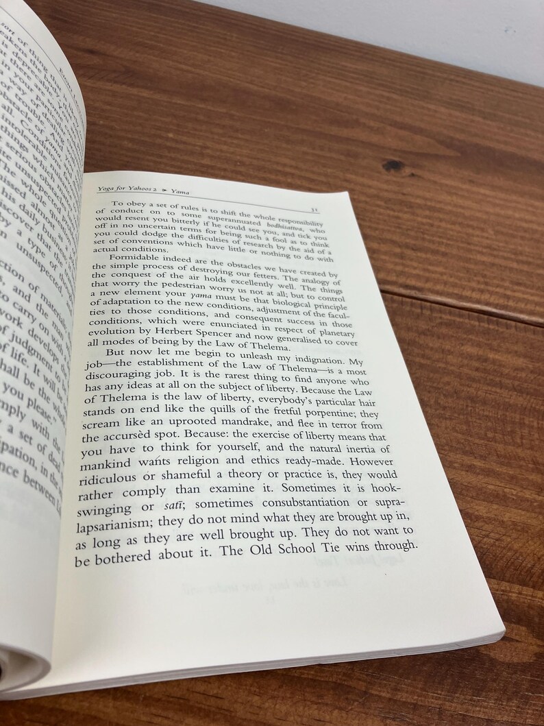 May include: An open book with text on a wooden surface. The text includes the title "Yoga for Yahoo 2 Yama". The page is open to a section discussing rules and liberty.
