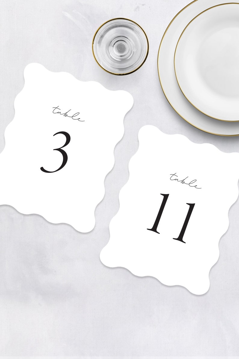 May include: Two white table number cards with scalloped edges. The card on the left says "table 3" and the card on the right says "table 11".