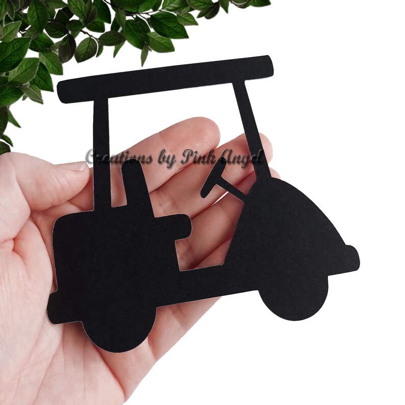 This image showcases a golf cart paper cutout held in a hand.  The golf cutout is made from black cardstock. These golf cutouts are great for events, party decorations, and scrapbooking.