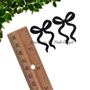 This image features a bow confetti pieces next to a ruler for size reference.