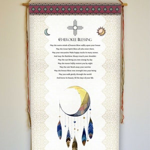 May include: A white canvas scroll with a Cherokee blessing printed in black text. The scroll features a watercolour illustration of a dreamcatcher with a crescent moon and feathers. The scroll is framed with a wooden dowel and red and white patterned fabric.